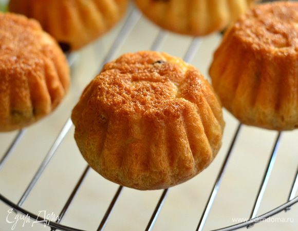 Готовые булочки аккуратно вынуть из формы, перевернуть на решетку, проколоть по глубже в нескольких  местах зубочисткой верхушку и дать остыть. Тем временем приготовьте сироп. Соединить воду с сахаром, поставить на средний огонь, варить 2-3 минуты, дать немного остыть, добавить ром или ромовую эссенцию, перемешать.