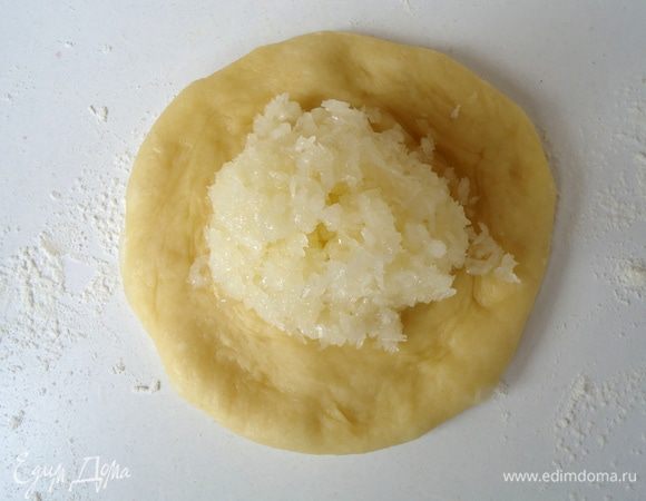 Каждый шарик размять руками в лепешку, положить на неё начинку и защипнуть.
