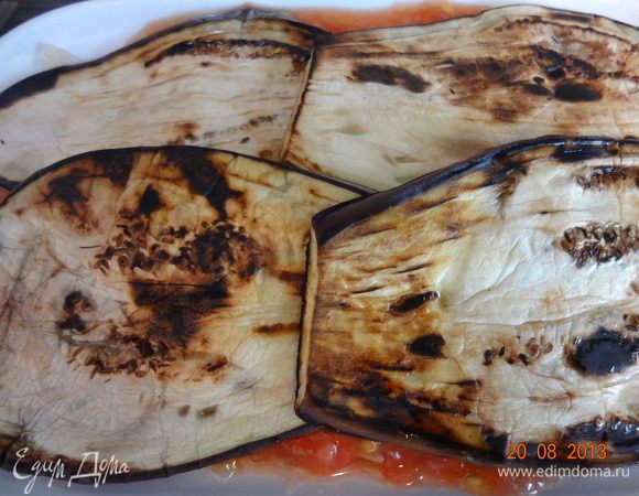 Сверху выложить оставшиеся пластинки баклажан, посыпать тертым сыром и отправить в разогретую до 180 С духовку на 30 минут, следить, чтобы верх не пригорал, накрыть фольгой и уменьшить температуру в таком случае.