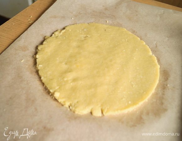 На пергаменте раскатать 1 большой комочек теста и выложить в форму для выпечки