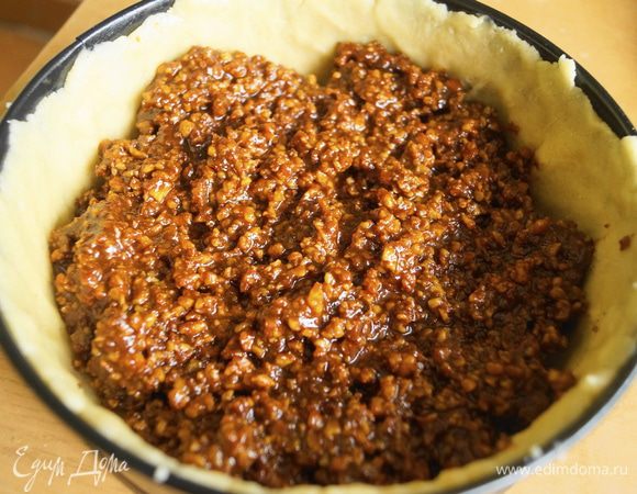 Сделать бортики из маленькой части теста. Выложить начинку и разровнять по всей форме.