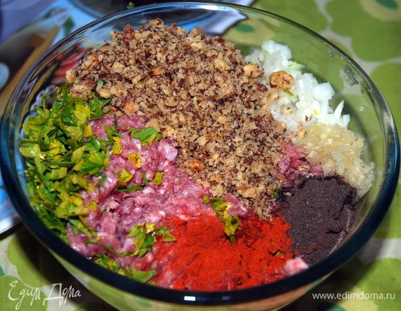 Фарш тщательно перемешать, давить мелкие орехи, нарезанные лук и чеснок, добавить специи; оставить в холодильнике на 20 мин