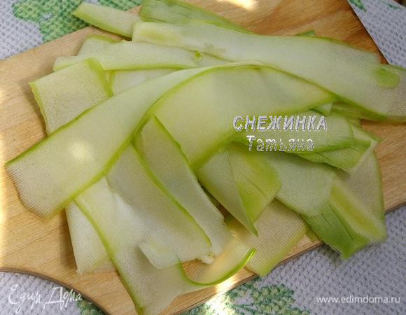 Цукини нарезаем очень тонкими пластинами. Я использовала овощечистку, можно сделать это очень тонким ножом.