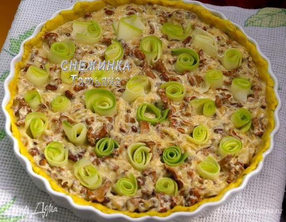 Выкладываем на тесто полученную грибную начинку, равномерно распределяем. Пластинки цукини заворачиваем в виде рулетиков. Укладываем их красиво на пирог, вдавливая в начинку.