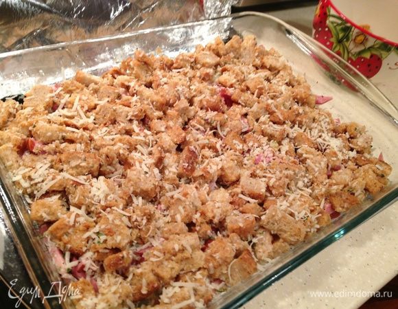 Выложить смесь с сухариками поверх остальных слоев в форму. Еще раз присыпать сыром и травами. 