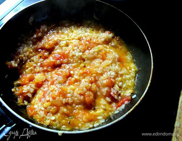 Рис промыть. На сковороде в масле попассеровать лук и томаты. Посолить. Положить толченые кедровые орешки. Затем добавить рис, и потушить под крышкой минут 15 на маленьком огне, чтобы рис распарился.