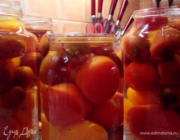 Залейте помидоры в банках кипятком (кипятка понадобится приблизительно половина объема банок). Через 10–15 минут воду из банок слейте (удобно использовать специальную сливную крышку, она бывает с отверстиями и носиком). Обычно рекомендуют после этого накрыть банки прокипяченными крышками, но я этого не делаю.