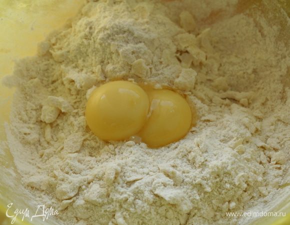 Далее добавляем желтки и замешиваем тесто. 