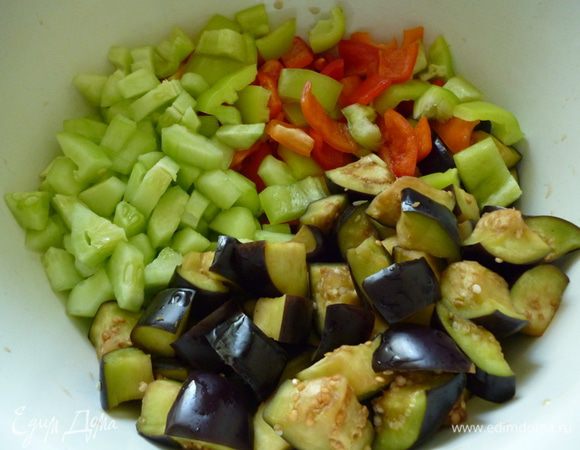 Баклажаны нарезать крупными кубиками,посолить,перемешать,дать постоять 20 минут, затем отжать руками. Огурцы почистить, нарезать кубиком. Болгарский перец нарезать крупным кубиком.