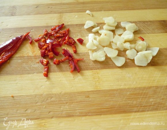 У горького перца удалить семена и нарезать его мелко,чеснок нарезать тонкими пластинками.Томаты разрезать пополам,натереть на крупной терке (без кожицы).
