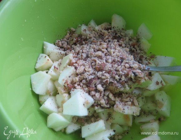 Яблоки очистить, порезать небольшими кубиками, полить лимонным соком. Орехи порубить, добавить к яблокам.