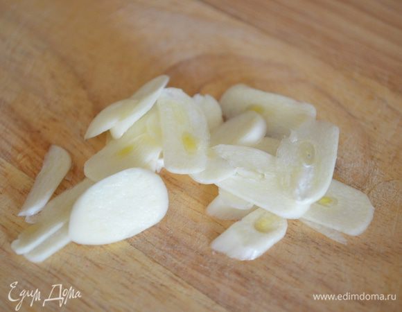 Чеснок нарежьте на тонкие пластинки.