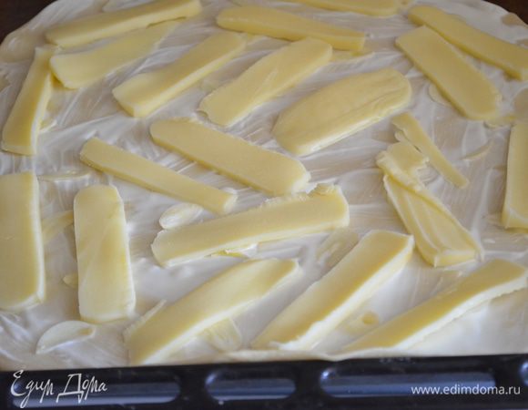 Разложите пластинки чеснока и кусочки моцареллы, посолите и посыпьте тимьяном.