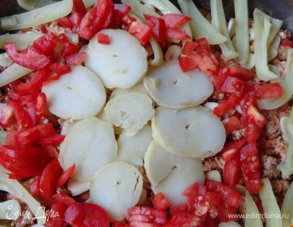 На фарш разложить нарезанный на пластиночки чеснок, затем нарезанный кружочками картофель, запеченный и нарезанный полосочками болгарский перец  и кусочки помидоров. Посолить, поперчить. 