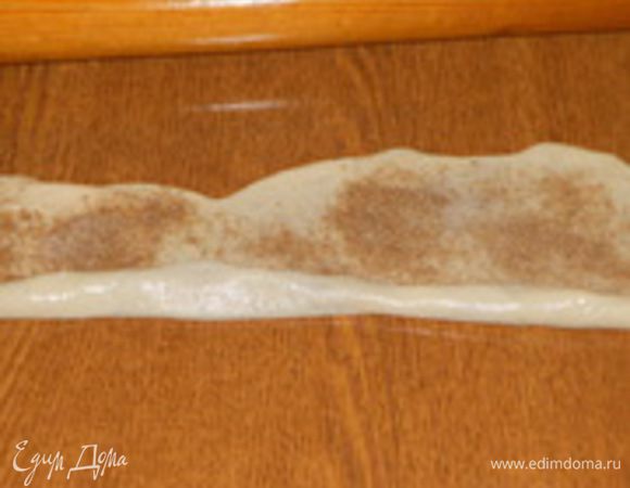 Каждую часть раскатать в прямоугольную лепешку, смазать размягченным маслом, посыпать сахаром и корицей.
Далее лепешку свернуть в рулет (трубочку) и скрутить улиткой.