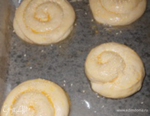 Смазать булочки яйцом и посыпать кунжутом.
Подготовленные плюшки с корицей уложить на смазанный противень, дать немного постоять (15-20 мин).
