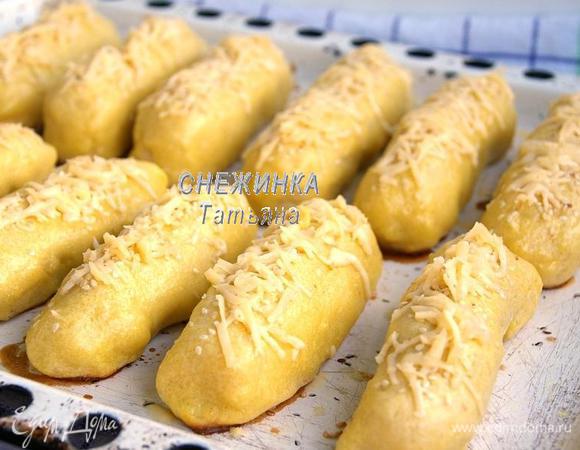 Ставим запекаться в духовку, разогретую до 200С, на 25 минут. Сыр натираем на крупной тёрке. Вынимаем сосиски в тесте, посыпаем сыром. Отправляем в духовку ещё на 10 минут.