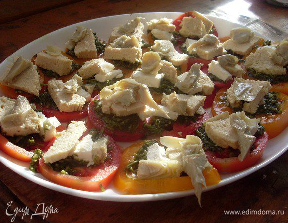 Разложить кусочки домашней куриной колбаски и кусочки артишоков.