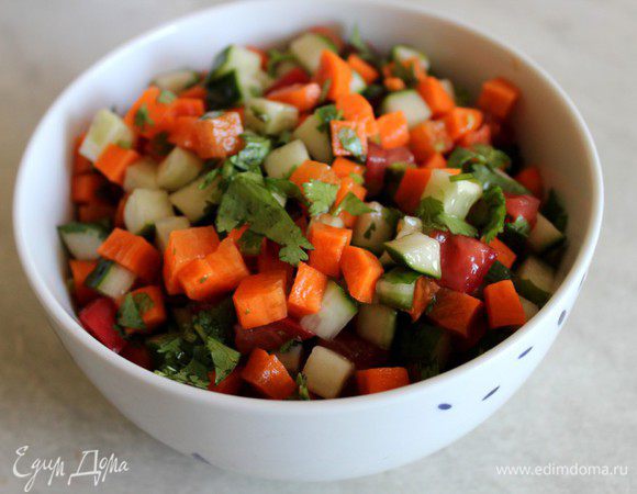 Перемешать морковь, огурец и кинзу, добавить мелко нарезанный помидор, посолить, полить лимонным соком и замариновать в течение часа.