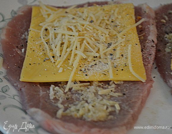 Поверх стейков выложить сыр пластинками, затем сыр Пармезан. Посыпать чесночной и луковой специей. Нет в продаже этих специй используйте натуральный лук и чеснок, мелко покрошив.