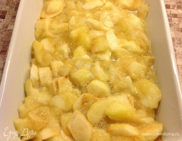 Смажьте форму сливочным маслом и выложите в нее яблоки.