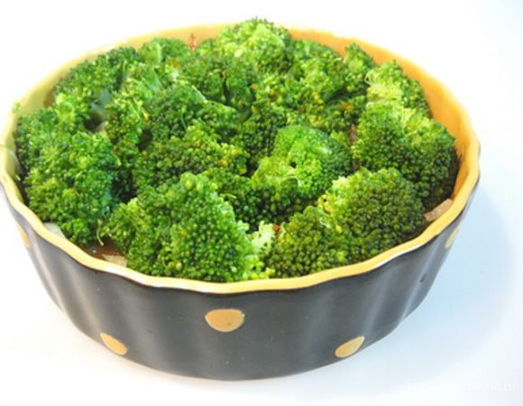 В форму для запекания выложить семгу, сверху пассерованный лук, затем брокколи.