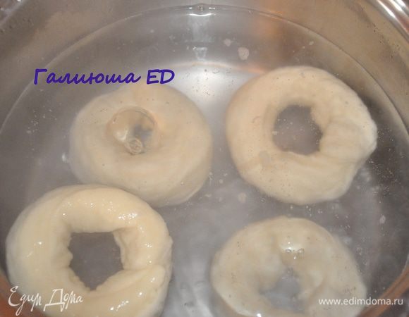  В средней кастрюльке доводим воду с сахаром и солью до кипения. Когда сахар и соль растворятся, бросаем несколько багелей и варим по 30 секунд с каждой стороны. 
