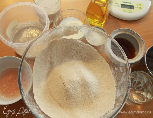 Приготовить все необходимые ингредиенты. Закваску предварительно вынуть из холодильника, чтобы пришла в себя при комнатной температуре, подкормить из общего объёма муки: примерно к 1/7 части закваски добавить по 80г муки и воды. В отдельной миске просеять всю муку. Дрожжи развести в тёплой воде (если у вас сильная закваска, дрожжи можно не использовать вовсе). 