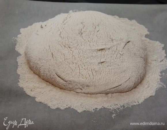Сверху обильно посыпаем мукой. Оставляем на расстойку на листе пекарской бумаги на 30 минут. После надрезаем в виде решётки (или любым другим узором).