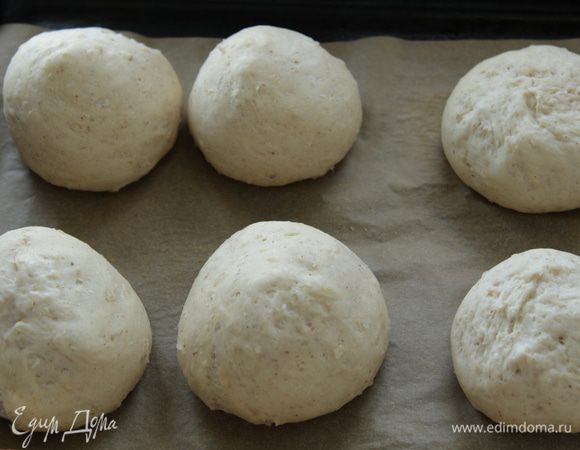 Как только тесто увеличится в 2 раза, обмять руками, сформировать небольшие булочки, выложить на противень на расстоянии друг от друга, смазать молоком и дать подойти в теплом месте еще раз.