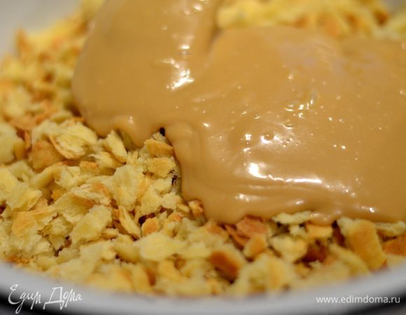 Выпеченное и покрошенное тесто перемешиваем с кремом ложкой, выкладываем горкой и ставим в холодильник для охлаждения. Украсить орешками, шоколадом.