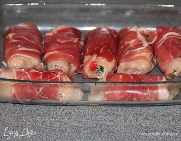 Каждый рулетик заворачиваем в полоску пармской ветчины. Выкладываем в жаропрочную форму слегка смазанную растительным маслом. И ставим в разогретую до 180 гр духовку на 20 минут.