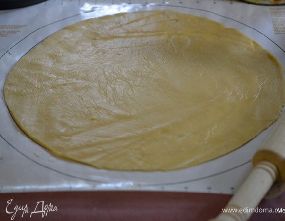 Если у вас ночь тесто отдыхало в холодильнике, дайте ему слегка отойти. Готовое тесто выложить на рабочую поверхность, по опыту предлагаю выложить на пищевую пленку, в которую заворачивали тесто. Предварительно чуть добавить муки.  Раскатать на 35 см  диаметр, если у вас форма 21 см.
 