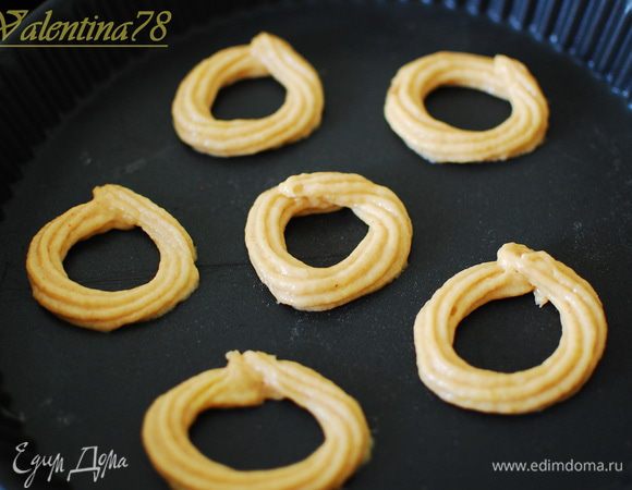 Выкладываем тесто в кондитерский шприц,и отсаживаем тесто в  виде колечек.(у меня противень тефлоновый,если используете обычные противень,застелите его пергаментной бумагой ,смазанной растительным маслом).
Выпекаем в предварительно разогретой до 180 градусов, духовке 7-9 мин на средней полке.