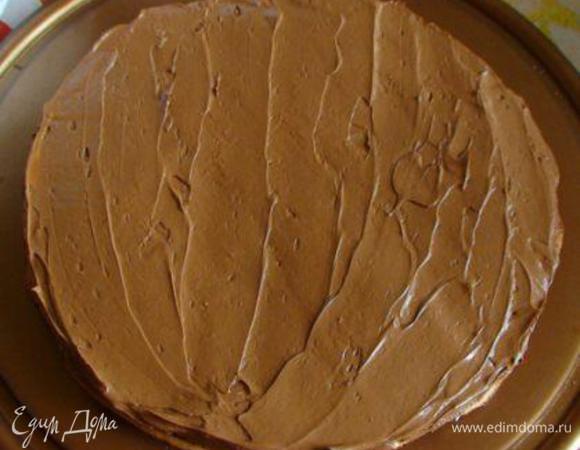 Тем временем все коржи (кроме одного) промазать кремом и сложить друг на друга, накрыть оставшимся коржом без крема.