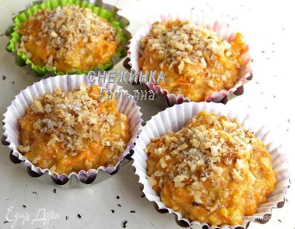 В металлически формочки для кексов кладём бумажные формочки. Наполняем тестом. Грецкий орех немного измельчаем и посыпаем поверх теста. Затем присыпаем сахаром.