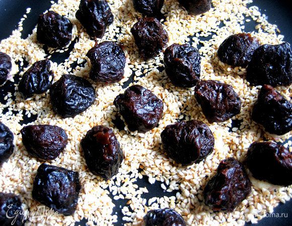 Теперь окунаем наши черносливины в солёный сезам и прижимаем слегка сыром вниз.