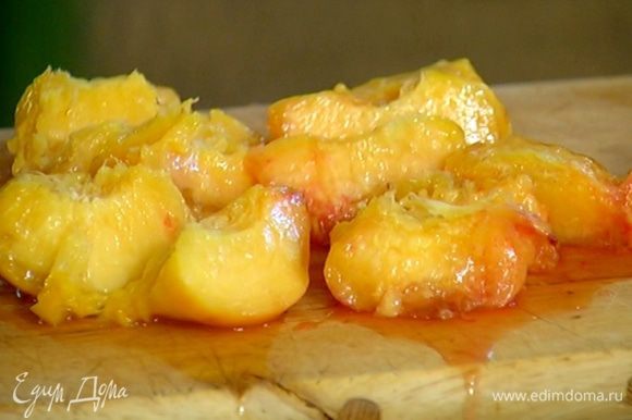Вынуть персики из сиропа, снять с них кожицу, разрезать пополам и, удалив косточку, нарезать кусочками.