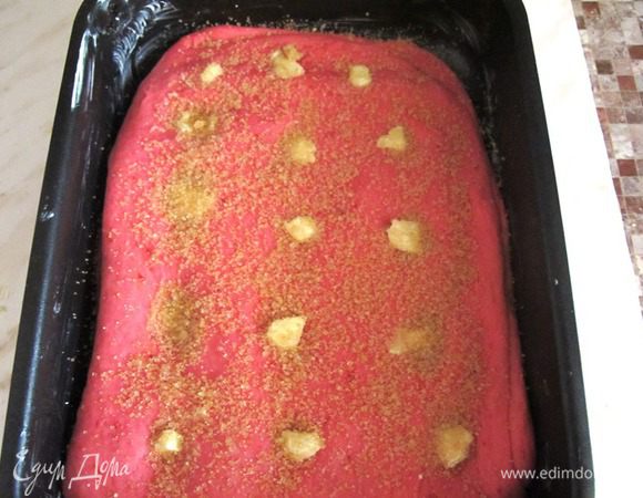 Раскатываем тесто по величине формы. Форму смазываем маслом, кладем в нее тесто. Пальцем делаем на поверхности несколько углублений и кладем туда капельку масла. немного посыпаем сахаром.