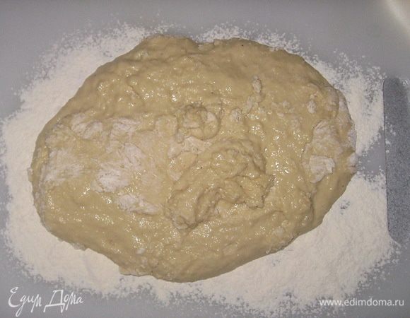 На стол насыпать муки и выложить тесто. Обминать 5 минут, пока оно не станет однородным и эластичным. 