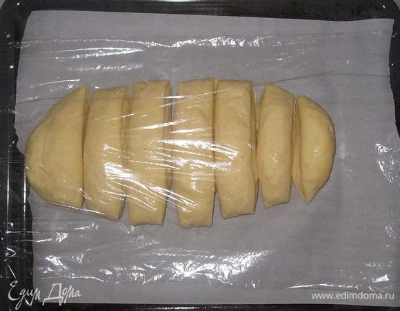 Противень застелить пергаментной бумагой. Выложить тесто и накрыть пленкой. Оставить на 20 минут для подъема. 