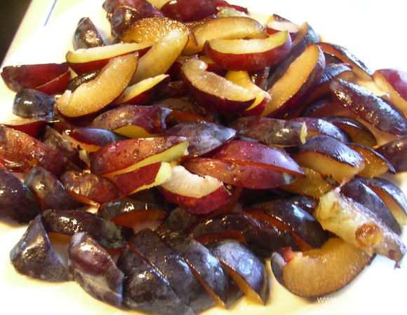 Сливы освобождаем от косточки и режем дольками.
