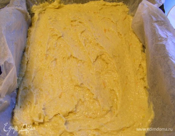 Форму выстилаем бумагой для выпечки. Выкладываем в нее половину теста.
