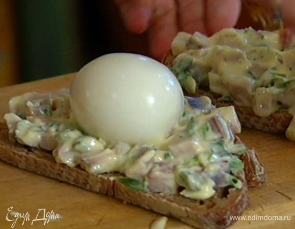 Хлеб намазать селедочной массой, на один кусок выложить целиком вареное яйцо, накрыть вторым куском хлеба, слегка придавить и разрезать бутерброд по диагонали.