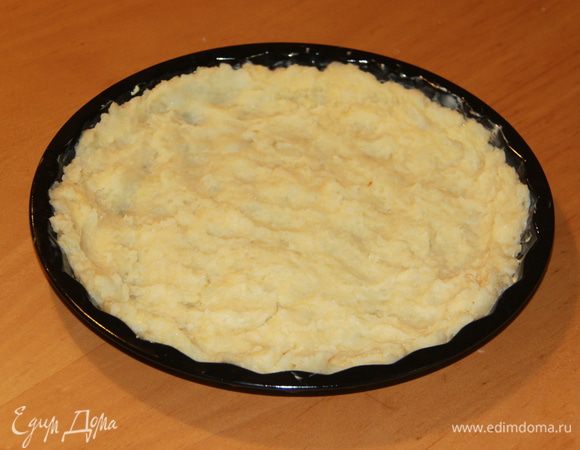 Выложить картофельную массу в форму с низкими бортиками, распределить по всей поверхности.