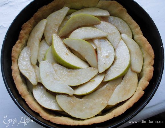 Достать тесто из духовки, вынуть бумагу вместе с фасолью. Уложить на корж груши.