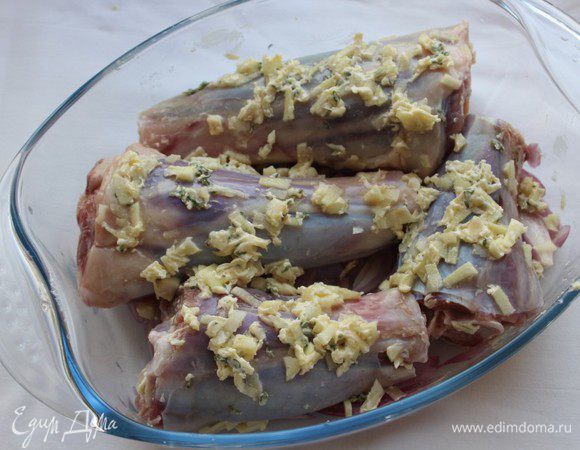 Натереть чесночной смесью помытые и обсушенные голяшки, выложить их на подушку из лука.