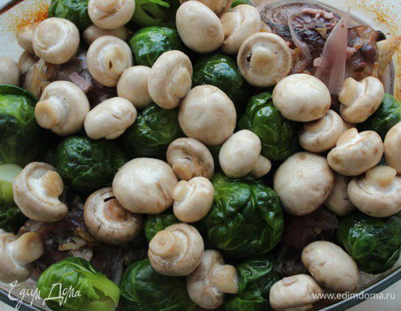 Через два часа достать мясо, выложить на него грибы и капусту.