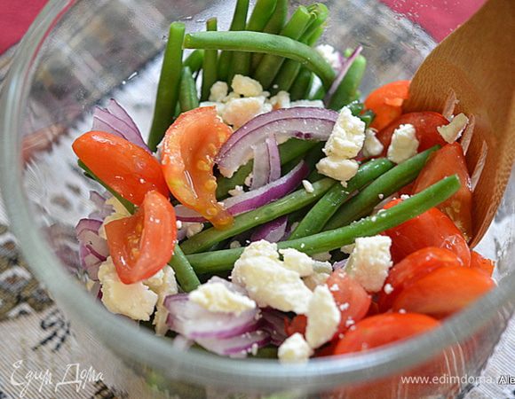 Слить воду , встряхнуть лишние капли, выложить в общее блюдо, добавить сыр Фета крошкой, помидоры на половинки, 1/4 часть порезанный лук.