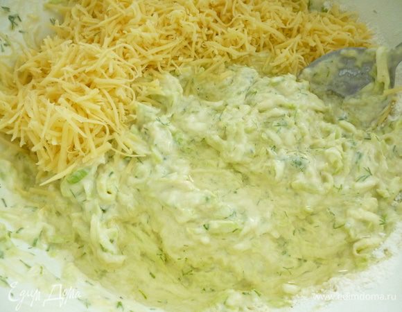 Добавить муку с разрыхлителем, перемешать. Добавить натертый мелкой стружкой сыр, растительное масло, перемешать.